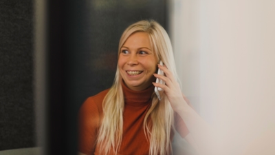 Looking in through glass on employee Petra Sahlstén while on a phone call